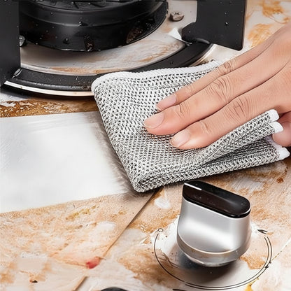 Person cleaning a stovetop with a metal scrubber